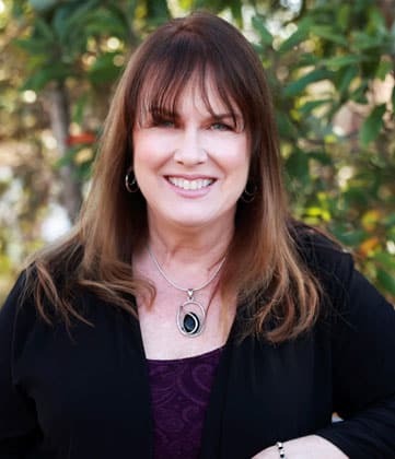 Professional female dentist smiling outdoors at Niceville dental practice.