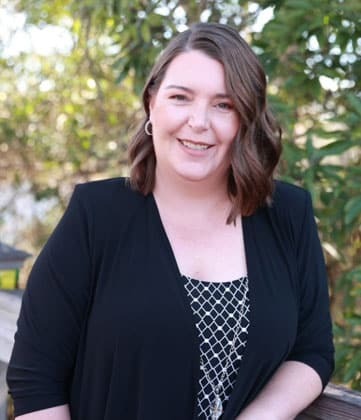 Professional female team member smiling outdoors at Niceville dental practice.