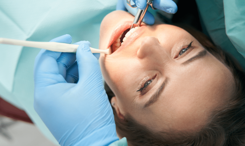Patient receiving dental treatment with dentist using professional instruments in Niceville.