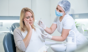 Female patient experiencing tooth pain during emergency dental visit with dentist in Niceville.