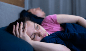 Woman resting on couch showing fatigue, a common symptom of sleep apnea.