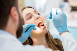 Dentist examining patient's teeth during cosmetic dental treatment in Niceville.
