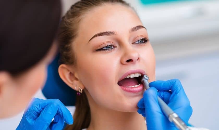 Dentist examining patient's teeth during cosmetic dental treatment in Niceville.