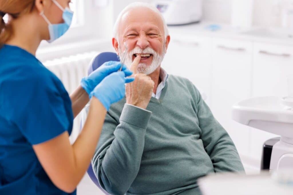 Senior man smiling during dental examination with dentist in Niceville, FL office.