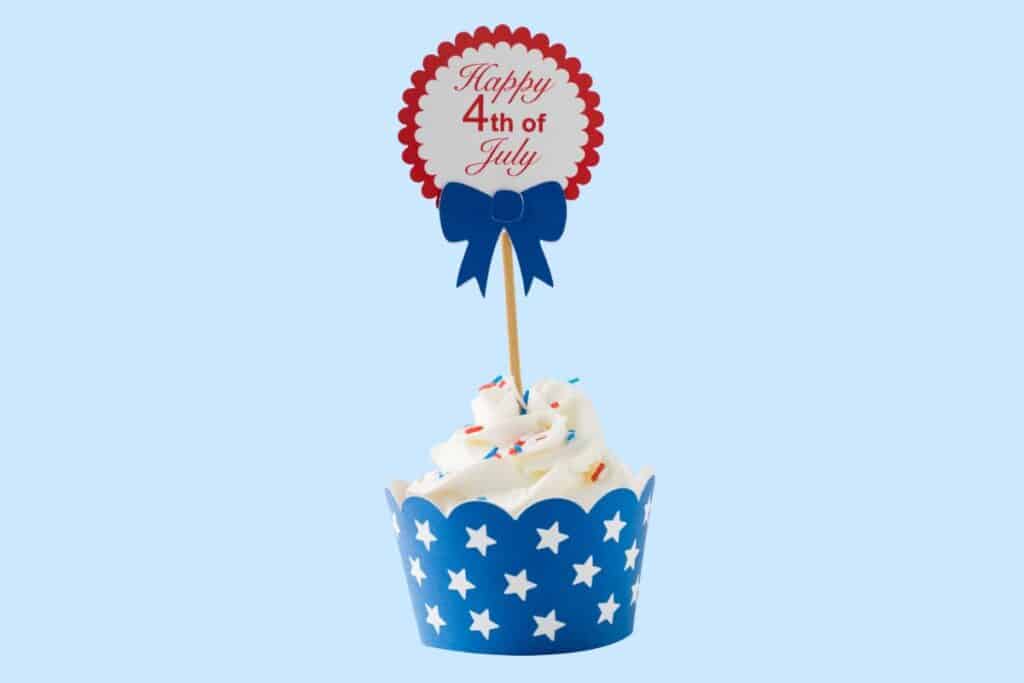 Patriotic Fourth of July cupcake with red scalloped topper and blue star wrapper symbolizing dental-friendly holiday treats.