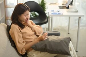 Woman holding a glass of water in a dental office, demonstrating tooth sensitivity relief.