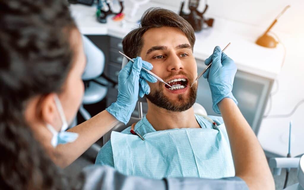 Man receiving dental examination from dentist in Niceville, FL office.