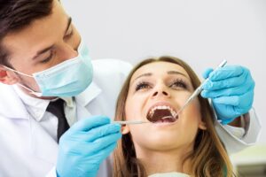 Dentist examining patient's teeth during emergency dental treatment in Niceville.