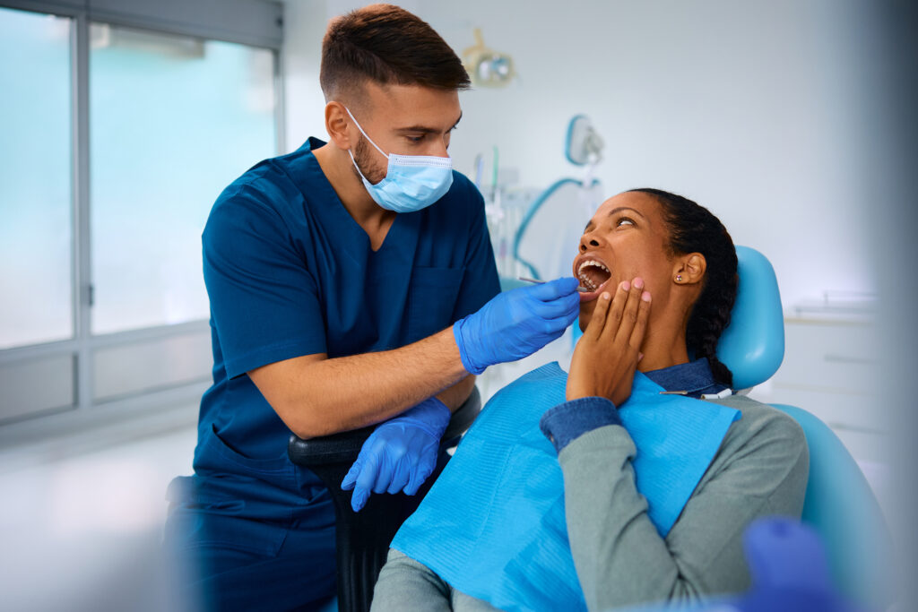 Dentist examining patient's teeth during oral checkup in modern dental office.