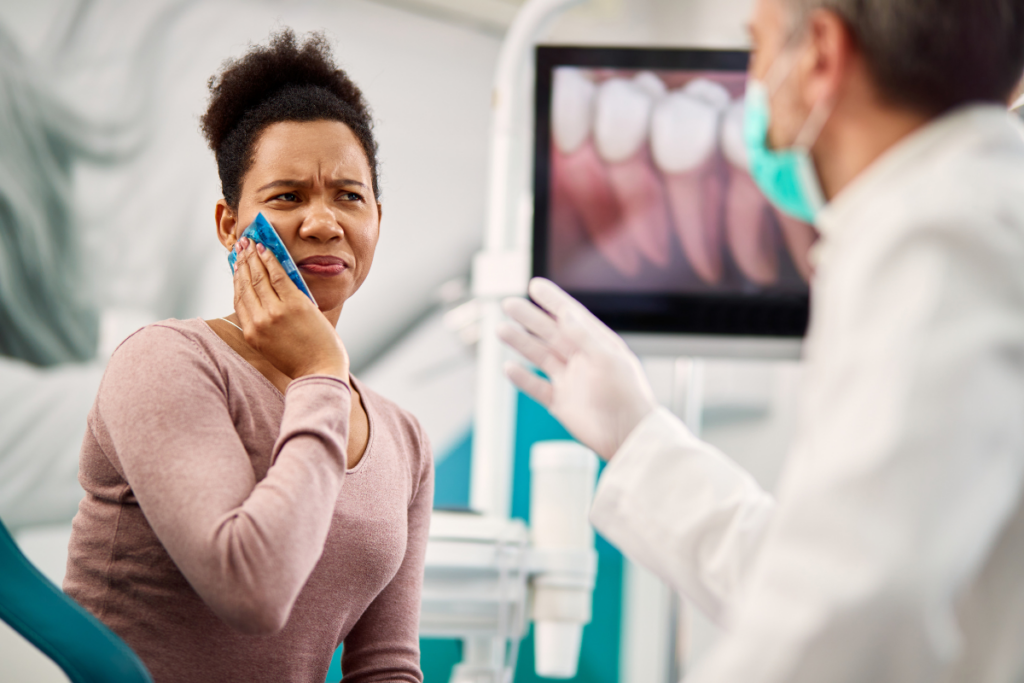 Patient experiencing tooth pain during consultation with dentist in Niceville, FL office.